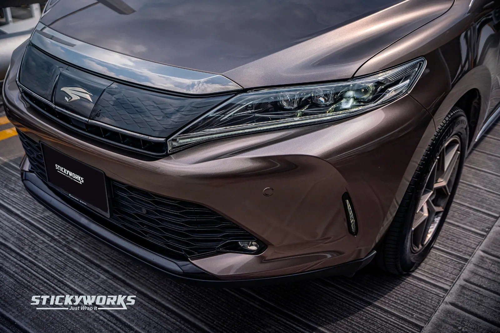 Close-up of the front grille and headlights on a brown SUV with a car wrap