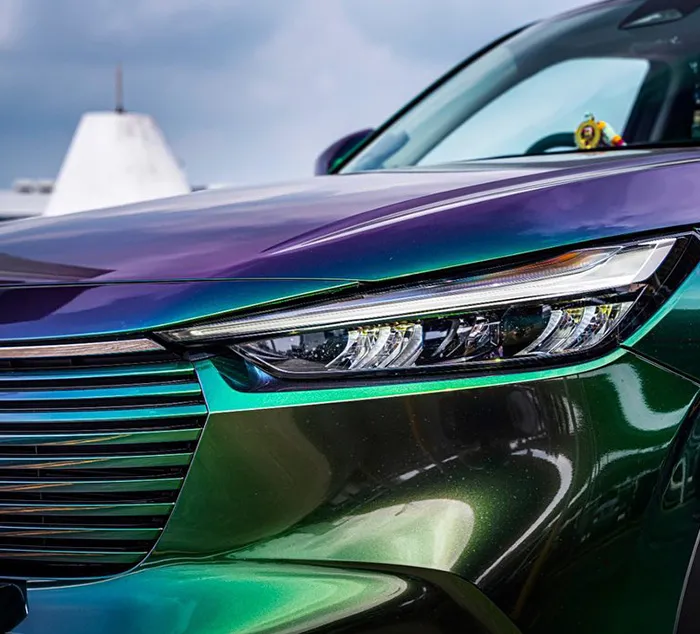 Close-up of a car headlight and grille featuring a car wrap