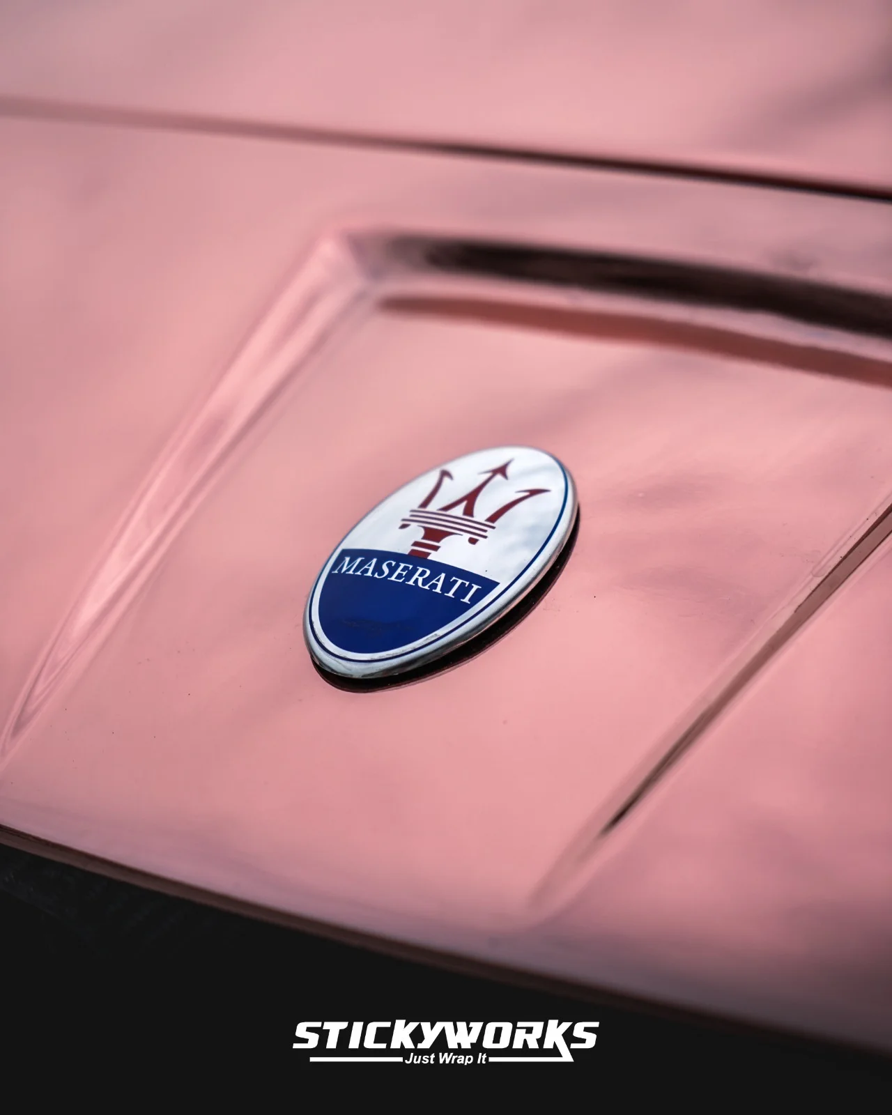 StickyWorks Maserati badge close-up on rose gold chrome wrap highlighting premium finish and smooth surface