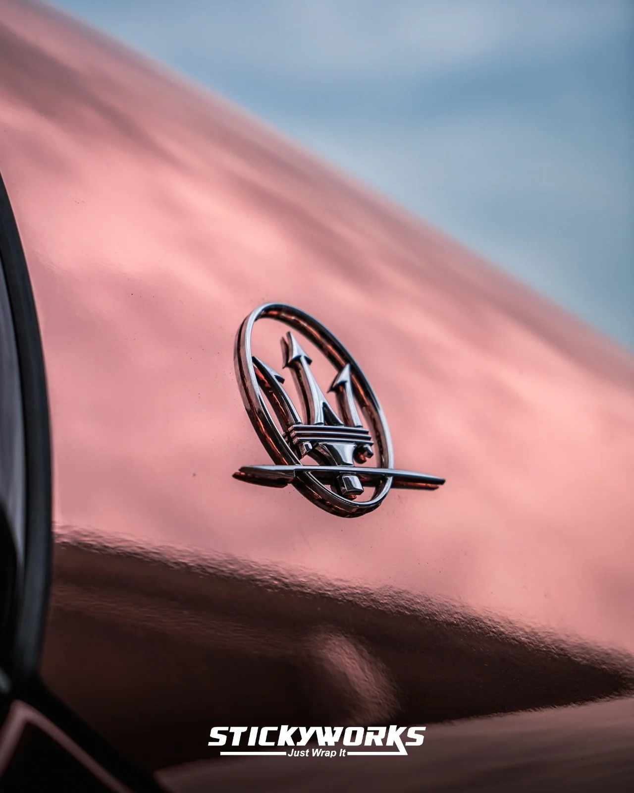 StickyWorks Maserati trident emblem detail on rose gold chrome wrap showcasing reflective high-gloss finish