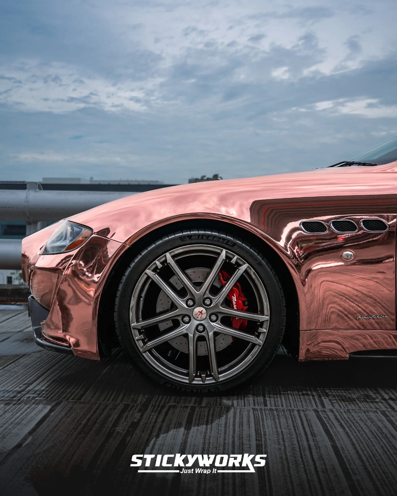 StickyWorks Maserati wheel and fender detail in rose gold chrome wrap highlighting reflections and precision installation