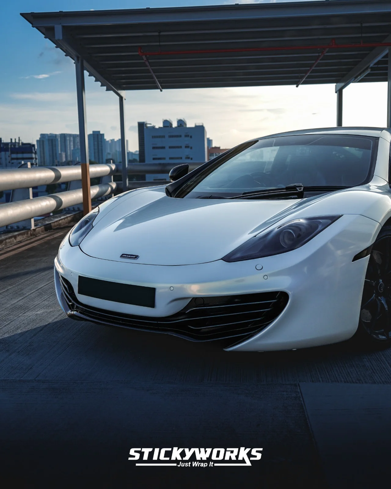 StickyWorks McLaren front angle shot in gloss white wrap showcasing sleek design and premium vinyl finish