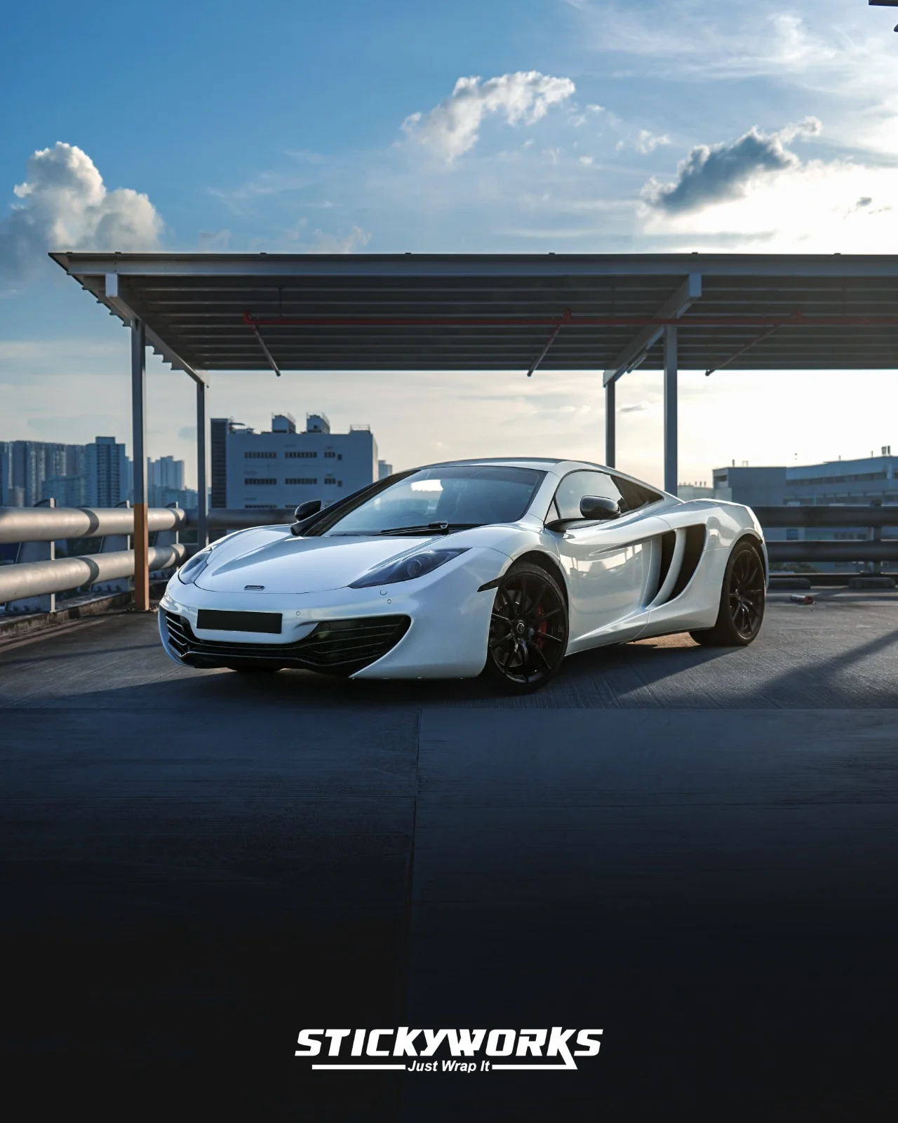 StickyWorks McLaren front wide shot in gloss white wrap emphasizing aggressive stance and clean vinyl finish