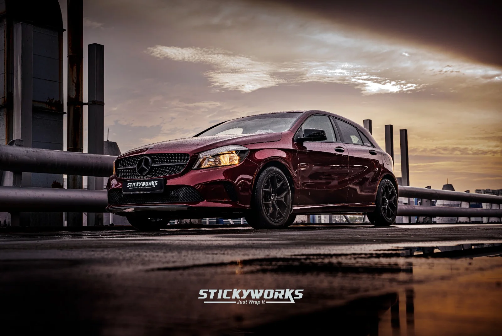 StickyWorks Mercedes hatchback front angle in gloss red wrap during golden hour highlighting depth and shine