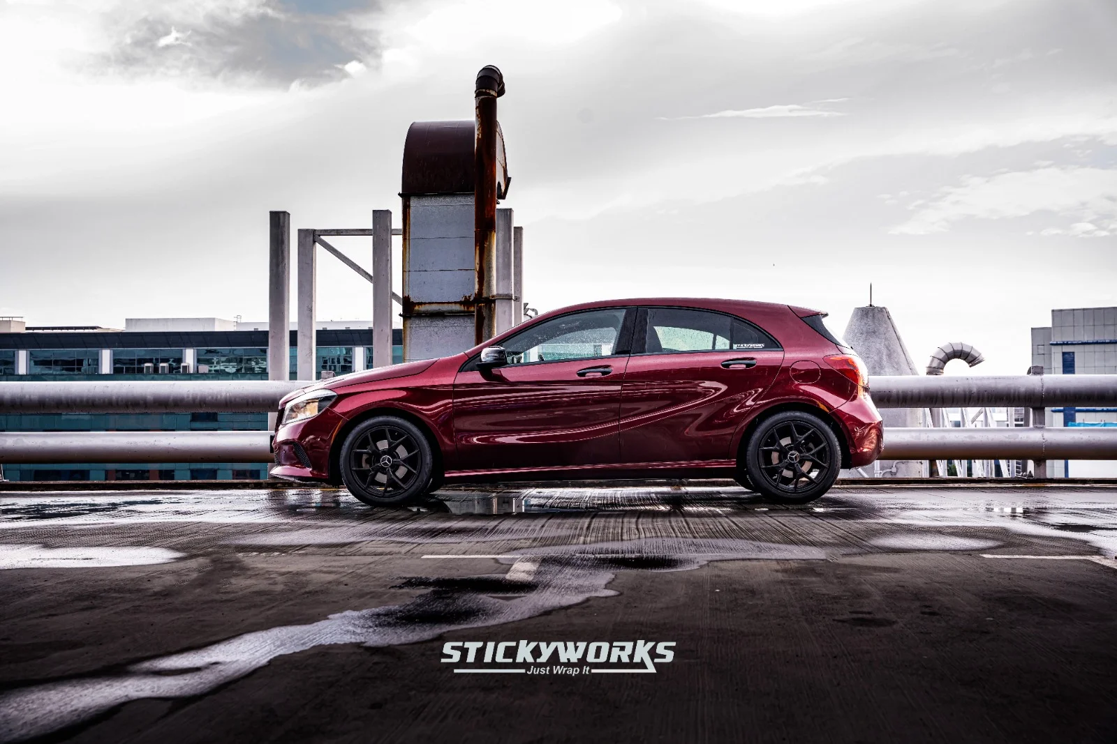 StickyWorks Mercedes hatchback side profile in gloss red wrap showcasing sleek lines and uniform vinyl application