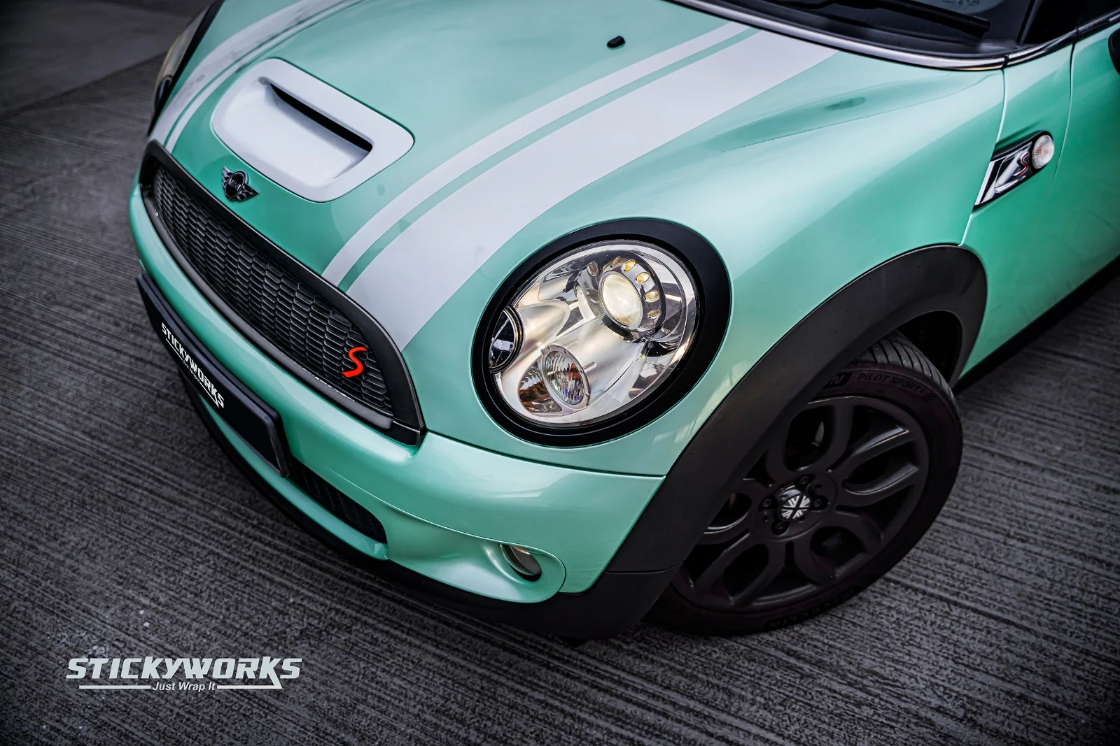 StickyWorks Mini Cooper headlight close-up with mint wrap showing detailed finishing and precision