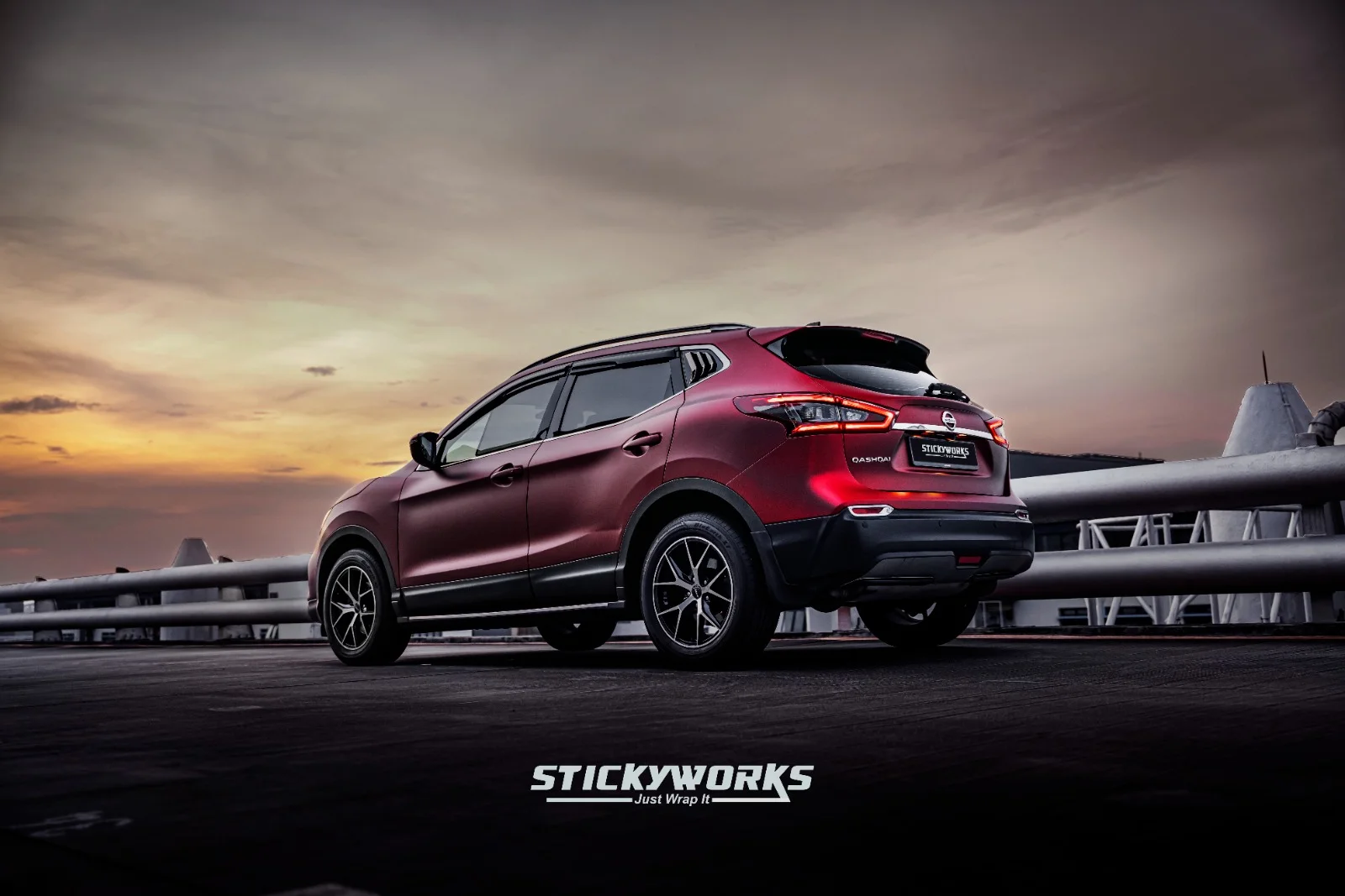 StickyWorks Nissan Qashqai rear view at sunset with red wrap showcasing reflective finish and premium detailing