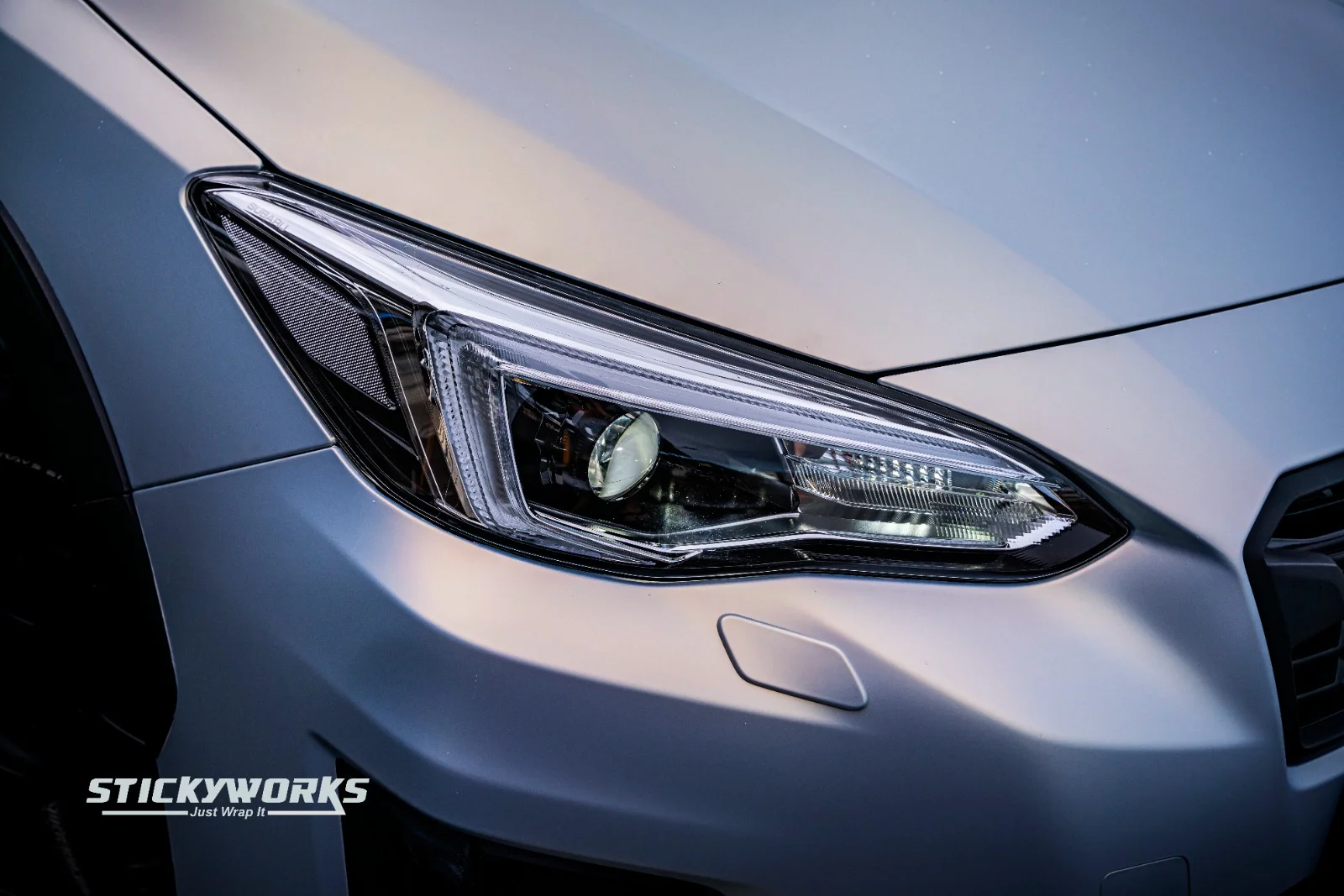 StickyWorks Subaru car wrap front low angle with headlights on highlighting wrap quality