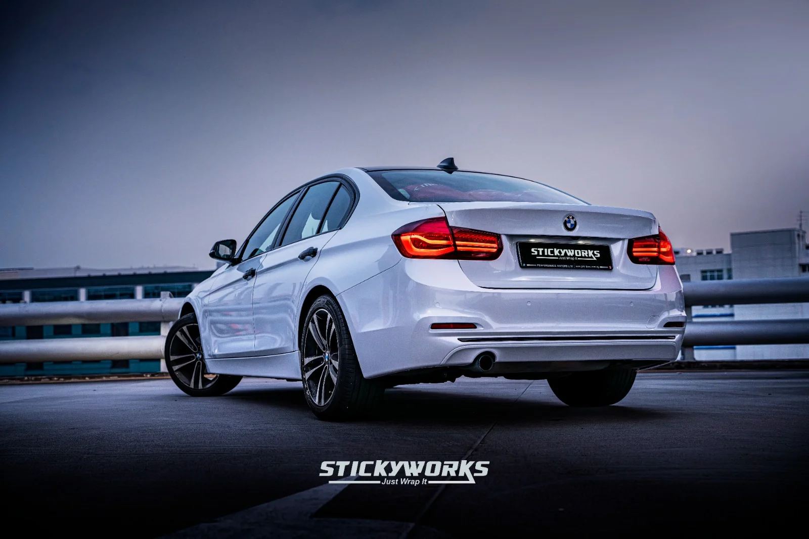 Rear angle of white BMW 3 Series showcasing clean wrap finish and taillight detailing in Singapore
