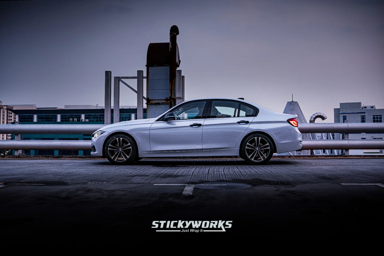 Side profile of white BMW 3 Series with seamless vinyl wrap and clean body lines