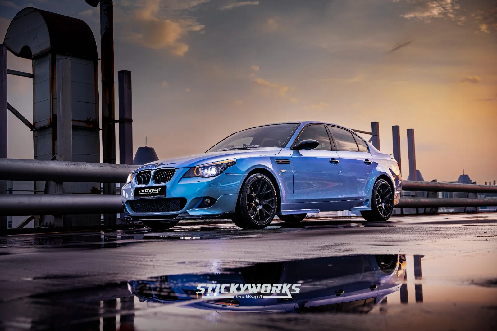 Rear angle of blue BMW M5 showcasing aggressive stance and vinyl wrap detailing