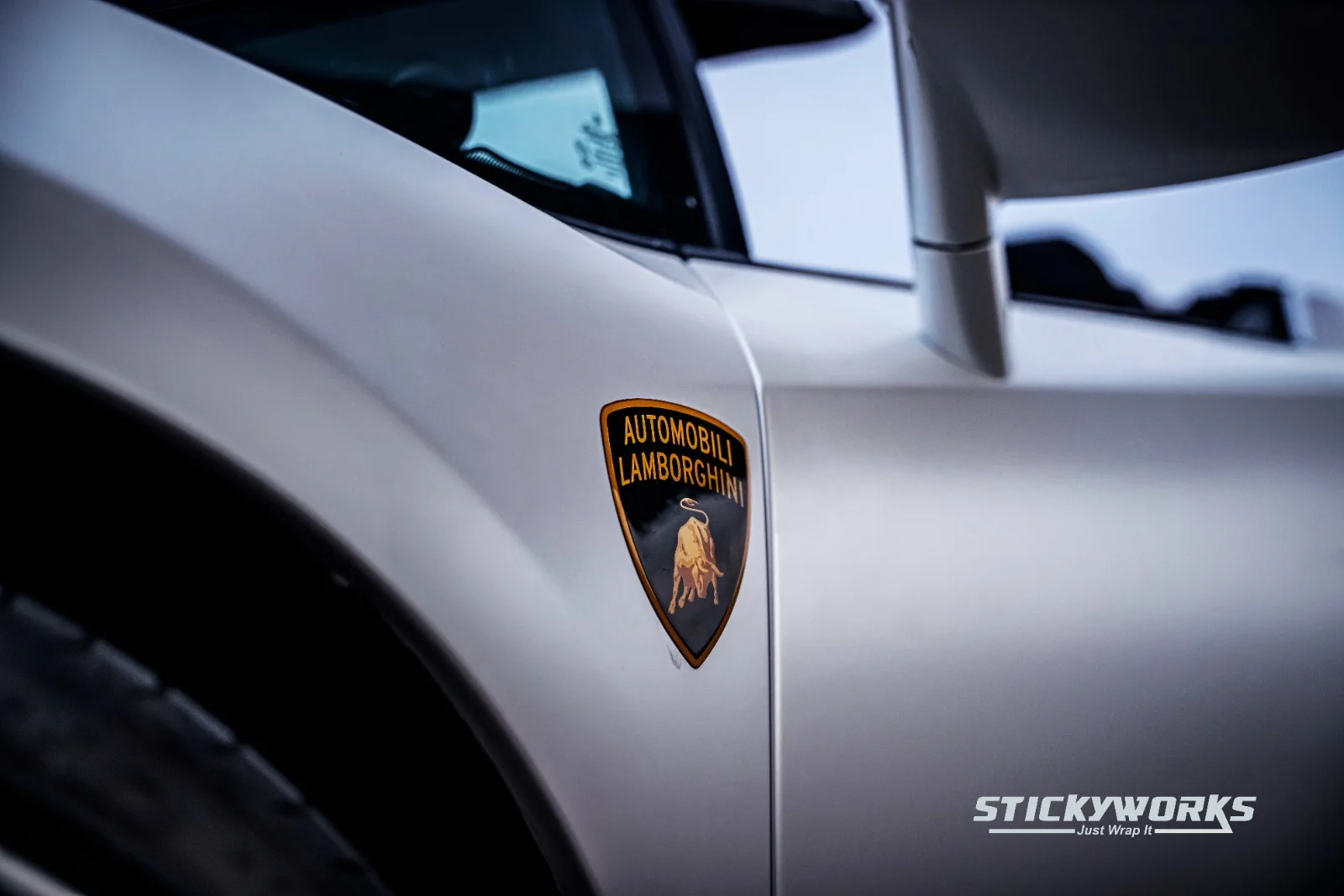 StickyWorks Lamborghini badge detail on matte white wrap showing texture and high-end finish