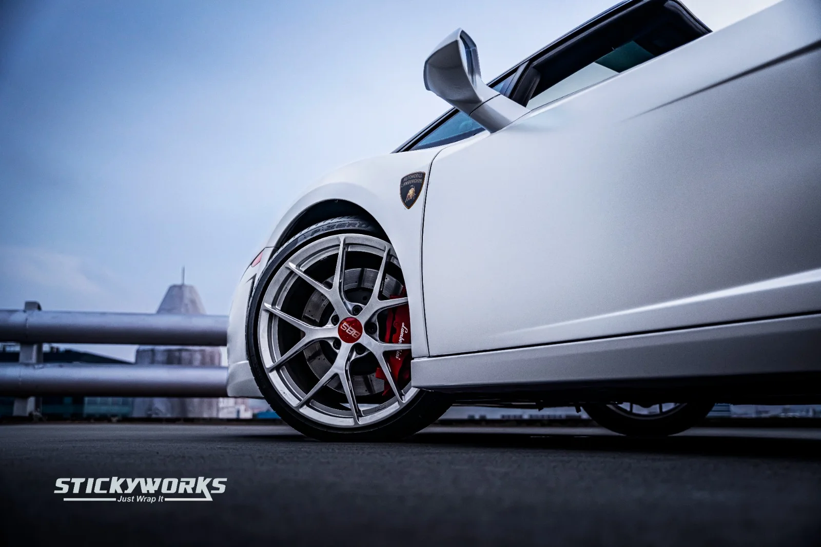 StickyWorks Lamborghini wheel and side detail in matte white wrap highlighting precision and premium finish